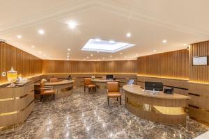 Golden Sands Suites في دبي: لوبي وجدران خشبية وطاولات وكراسي