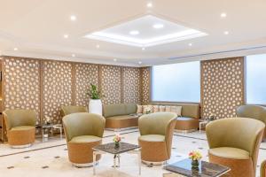 Golden Sands Suites في دبي: غرفة انتظار في الفندق مع الكراسي والطاولات