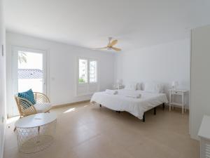 a white room with a bed and a chair at Pasitoblanco Porto Mare 44 Seaview Villa private heated pool in Pasito Blanco