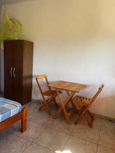 una mesa de madera y 2 sillas en una habitación en Pousada Serra Aquarela - Mini casas en Ibicoara