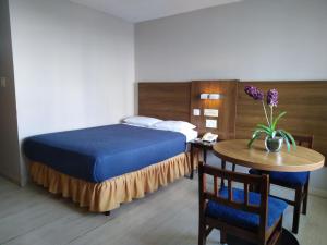 Habitación de hotel con cama y mesa con sidra de mesa en Hotel Tower House Suites, en Panamá