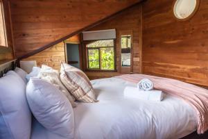 1 dormitorio con 1 cama grande en una cabaña de madera en Pixies at Eco Bay, en Port Campbell
