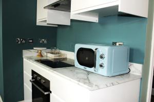 a microwave sitting on a counter in a kitchen at Lovely, cosy 3 bedroom apartment in Teddington