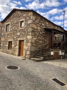 a stone building with a door on the side of it at Casa de Xisto Santo António in Videmonte