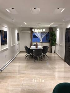 a dining room with a table and black chairs at Lilly court estate area 11 apartment in Abuja