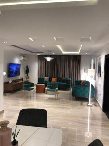 a living room with blue couches and a tv at Lilly court estate area 11 apartment in Abuja