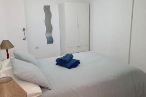 Una cama con una toalla azul encima. en Ocean View Apartment Poris en Poris de Abona