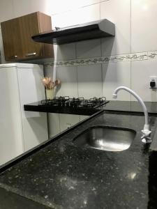 encimera de cocina con fregadero y fogones en Casa Vitória en Camocim