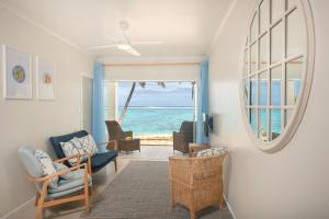 Vaima Beachfront Apartments في راروتونغا: غرفة معيشة مطلة على المحيط
