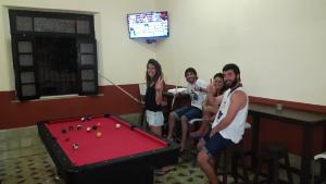 a group of people standing around a pool table at Hostal La Ermita in Mérida