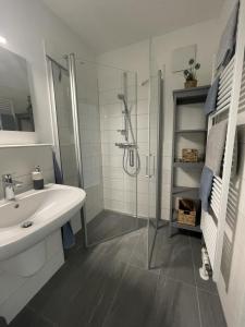 a white bathroom with a shower and a sink at Ferienwohnung Moin! in Damp +9 photos