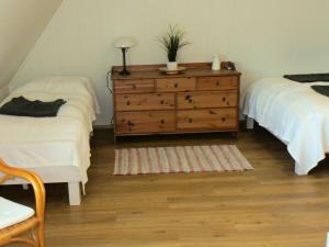 a bedroom with two beds and a wooden dresser at Ferienhaus Frieda - Urlaubsparadies unter Reet in Damp