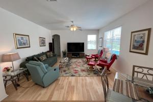 sala de estar con sofá, sillas y TV en Destination Beach Stroll en Fort Myers