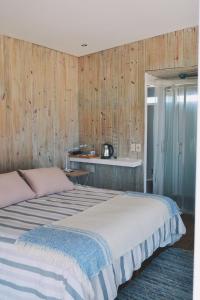 1 dormitorio con 2 camas y paredes de madera en Remanso del Diablo, en Punta del Diablo