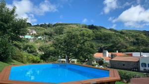 ein Swimmingpool mit einem Berg im Hintergrund in der Unterkunft Casa do Milhafre - Villaverde Azores in Feteiras