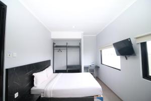 a bedroom with a bed and a flat screen tv at Bale Resident in Jakarta