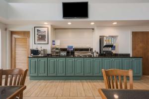 una hall con un bar verde con una tv sopra di Best Western University Inn a Tuscaloosa