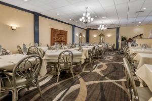 uma sala de jantar com mesas e cadeiras e um lustre em Best Western Fort Washington Inn em Fort Washington