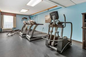 a gym with tread machines in a room with blue walls at Best Western Fort Washington Inn in Fort Washington