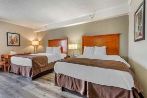 a hotel room with two beds and a desk at Best Western Fort Washington Inn in Fort Washington +18 photos