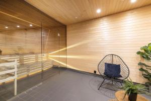 a rattan chair in a room with a wooden wall at Best Western Princess Hotel in Norrköping