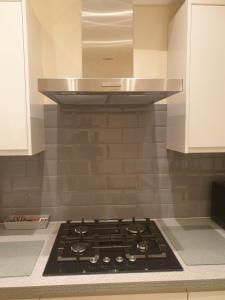 a kitchen with a stove top oven in a kitchen at London Luxury Apartment 3 Bed 1 minute walk from Redbridge Stn Free Parking in Wanstead