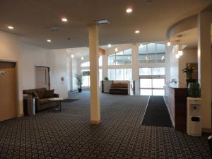 een grote lobby met banken en stoelen in een gebouw bij South Hill Motor Inn in Red Deer