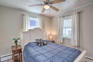 - une chambre avec un lit bleu et un ventilateur de plafond dans l'établissement Lakefront Cottage with Fishing and Private Yard!, à Port Clinton