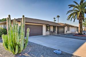 a cactus in front of a house with a garage at Quiet Sun City Home with Patio, Community Pool! in Sun City