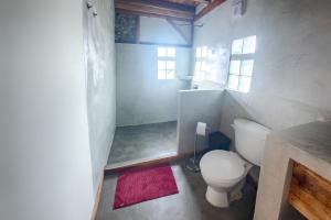 a small bathroom with a toilet and a shower at Vistamar Guest House in Ayampe