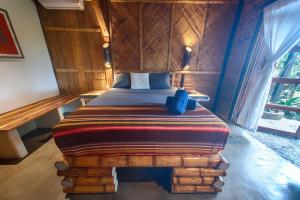 Schlafzimmer mit einem Bett aus Holz in der Unterkunft Vistamar Guest House in Ayampe