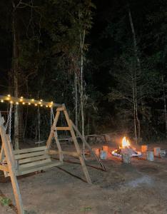 ein Lagerfeuer mit einer Holzschaukel und einer Feuerstelle in der Unterkunft PAMPA HERMOSA LAKE RESORT in Puerto Maldonado