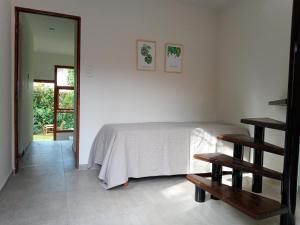 1 dormitorio con 1 cama y 2 bancos de madera en casita moderna frente al bosque en Mar del Plata