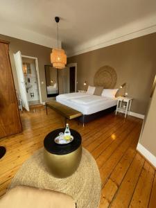 ein Schlafzimmer mit einem Bett und einem Tisch in einem Zimmer in der Unterkunft AUERSTEIN-Hotels auerstein & auerstein-mono in Heidelberg