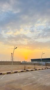 un estacionamiento con la puesta de sol en el fondo en Aljadel hotel, en Al Kharj