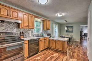 a large kitchen with wooden cabinets and a dining room at Charming Pentwater Home with Fire Pit and Yard! in Pentwater