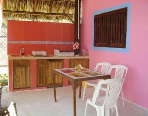 a kitchen with a table and chairs and a pink wall at Hotel Gilda in Coyuca