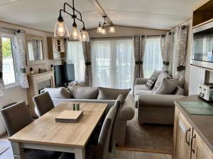 3 Bedroom Caravan MC34, Lower Hyde, Shanklin, Isle of Wight في شانكلين: غرفة معيشة مع أريكة وطاولة