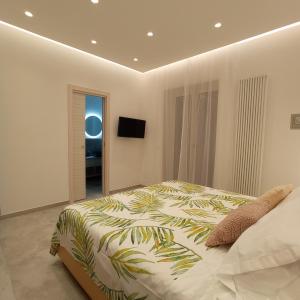1 dormitorio con 1 cama grande con estampado tropical en Alloggio nuovissimo al centro e rilassante en Ischia