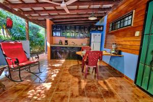 a kitchen with red chairs and a table in a room at Casa Smilin' Dog in Tamarindo
