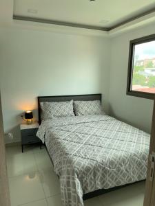 a bedroom with a bed and a window at Brand New 1Bdr Condo! 5 minutes from Famous Walking Street! in Pattaya South