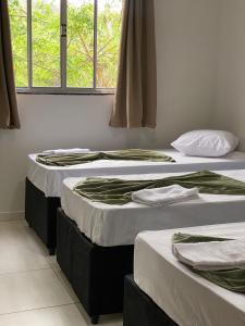 2 Betten nebeneinander in einem Zimmer in der Unterkunft Garden Hotel in Aparecida