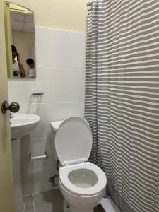 a bathroom with a white toilet and a sink at VBermor Hotel in Santo Domingo