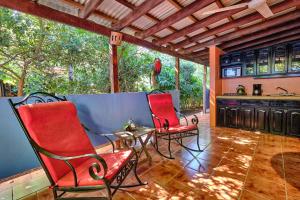 2 sillas rojas y una mesa en el patio en Casa Smilin' Dog en Tamarindo
