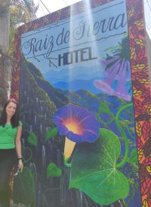 a woman standing in front of a sign with a flower at Hotel Raíz de Sierra in Matlapa