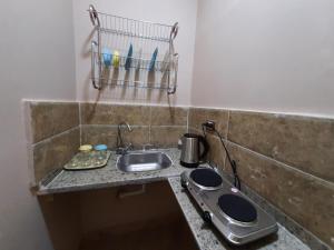 - un comptoir de cuisine avec évier dans l'établissement Aton pyramids view guest house, au Caire