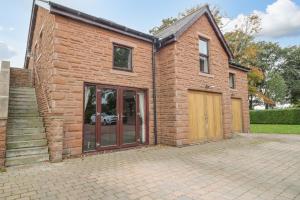 a brick house with a wooden door and stairs at The Annexe, Melbourne House in Penrith