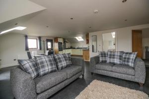 a living room with two couches and a kitchen at The Annexe, Melbourne House in Penrith