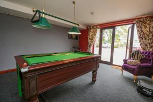 a billiard room with a pool table and two chairs at The Annexe, Melbourne House in Penrith