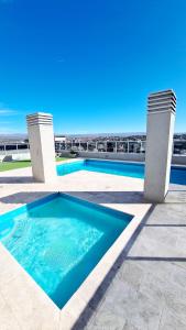 a swimming pool with the ocean in the background at II Opera Towers Villa Carlos Paz in Villa Carlos Paz